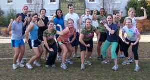 Active young adults posing for a photo outside.